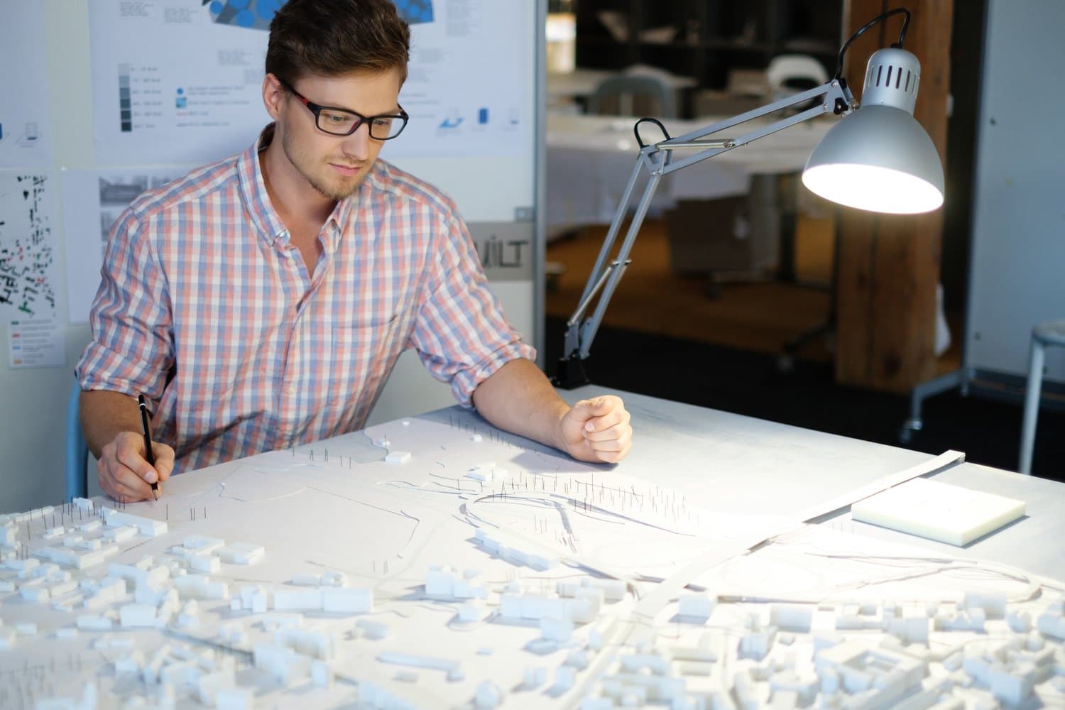 Arquitecto trabajando sobre planos en una mesa de dibujo